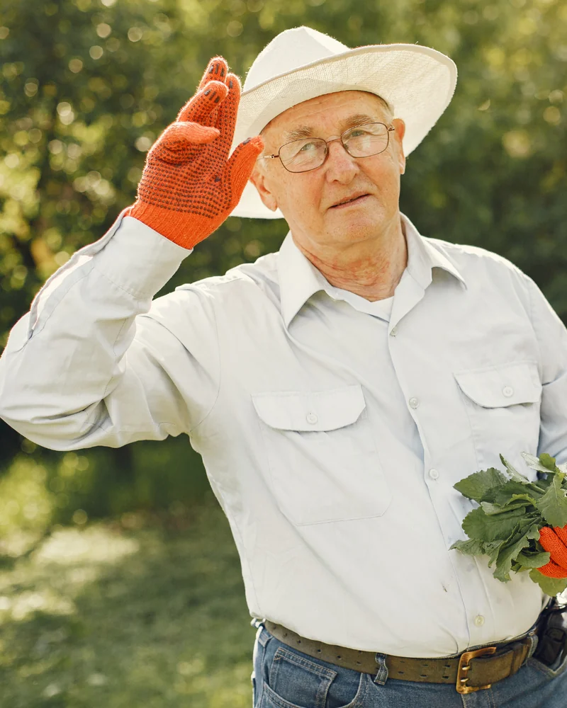 An older man happily tending his garden